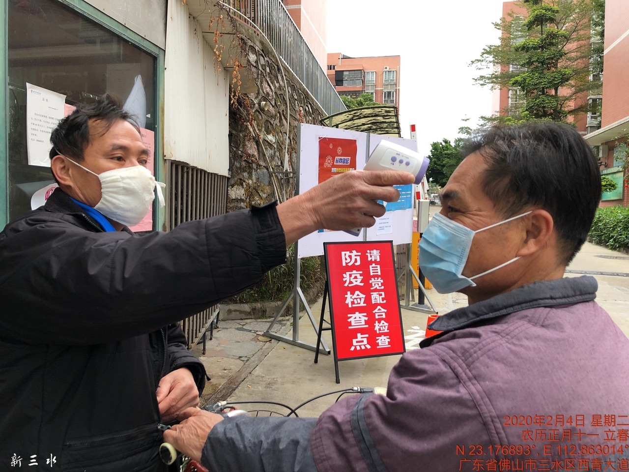 随疫情的严峻,出入小区的人员测体温.