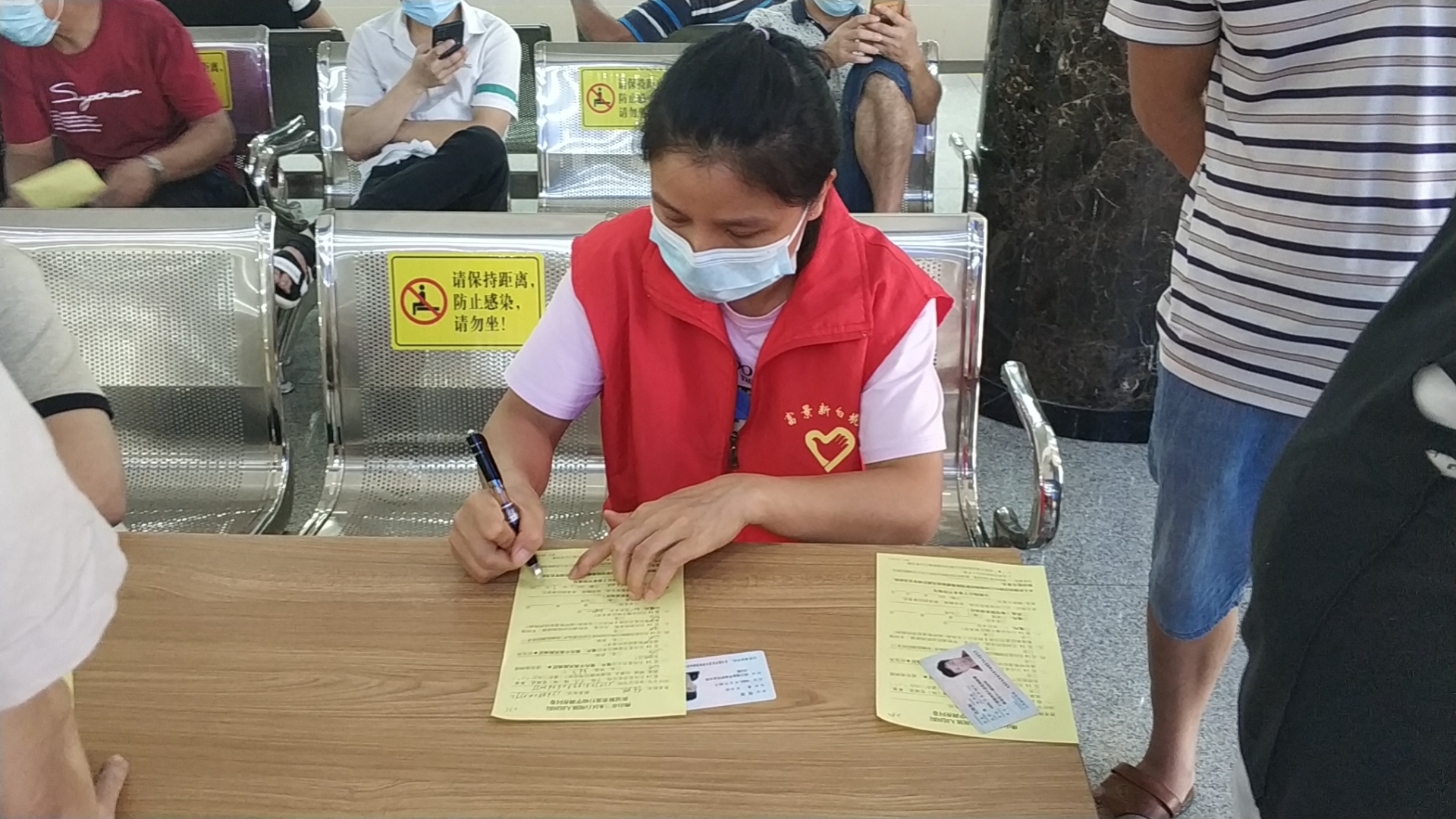 21.714 白坭镇人民医院 志愿者协助长者们填写疫苗及饿哦组了表格.jpg