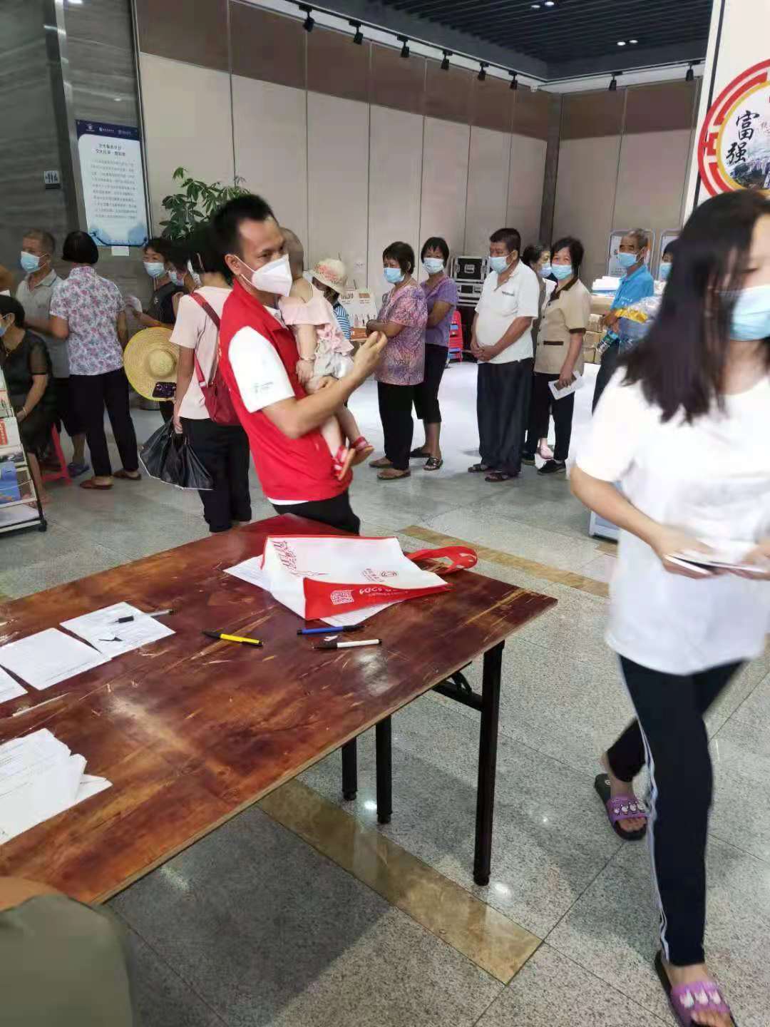 21.712文化活动中心 （感动）志愿者帮市民抱着bb，让家长安心接种疫苗.jpg